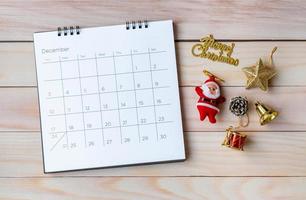 December kalender och juldekoration - jultomten och gåva på träbord. jul och gott nytt år koncept foto