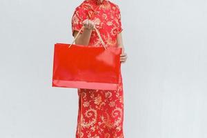 asiatisk kvinna med shoppingväska, kvinna bär cheongsam, kinesiska nyåret foto