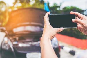 närbild av man som använder smartphone med isolerad skärm efter bilolycka foto