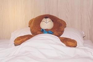 nallebjörn som ligger i sängen foto