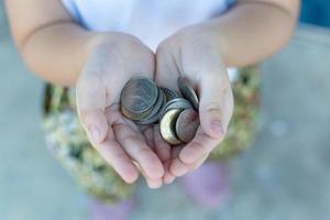 mynt i barn hand. affärs- och finanskoncept foto