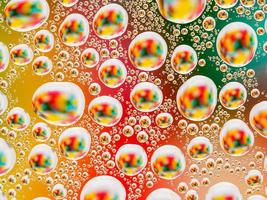 abstrakt färgglad levande bakgrund med stora och små sfäriska konvexa droppar vatten på glaset. makro, ovanifrån, närbild. foto