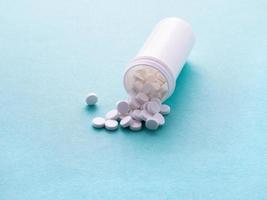 vit öppen behållare med ett läkemedel och piller foto
