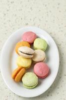 färgglada mini macaroon på vit platta foto