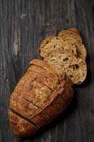 läckra hemlagade skivat bröd på mörk trä rustik bakgrund. foto