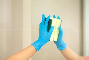 hygien. städar händerna. tvätta badrum med svamp och sprit spray eller tvål över handfat i badrummet, närbild. covid19. coronavirus. foto