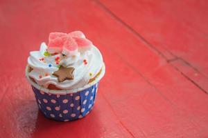 läckra cupcakes med smörkräm, på färg trä bakgrund foto