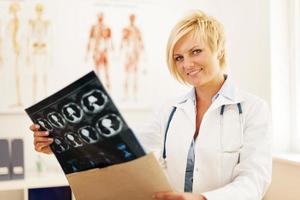 unga kvinnliga läkare som öppnar kuvertet med hjärntomografi