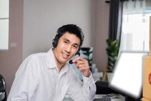 Asiatisk manlig hand som skriver beställ produktlista på lapp för onlinekund på lager hemmakontor som beställer produkter från online till företagsfraktförsörjning marknadstjänstleverans från hemmakontor. foto