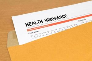 ansökningsblankett för sjukförsäkring på brunt kuvert foto