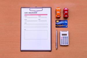 bilförsäkringsblankett med modell och försäkringsdokument foto