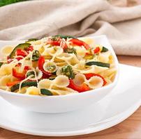 pasta med zucchini och paprika med basilika-vitlöksdressing foto