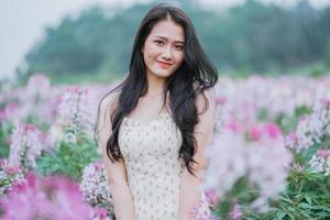porträtt av ung asiatisk kvinna på blommor fält foto