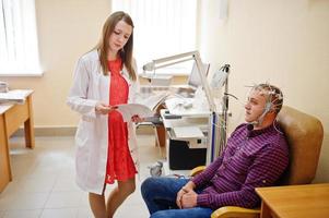 attraktiv läkare i vit rock undersöker hennes patients hälsa. foto