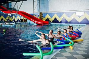 fitness grupp av flickor gör aerobiska övningar i poolen på vattenparken. sport och fritidsaktiviteter. foto