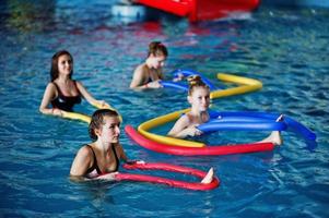 fitness grupp av flickor gör aerobiska övningar i poolen på vattenparken. sport och fritidsaktiviteter. foto