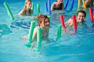 fitness grupp av flickor gör aerobiska övningar i poolen på vattenparken. sport och fritidsaktiviteter. foto