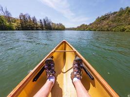man i liten gul pack kanot paddlar nerför floden monongahela i morgantown foto