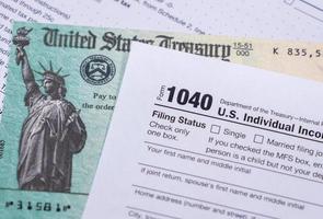 USA:s treasury check för stimulans 2020 mot en usa blankett 1040 foto