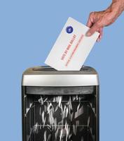 frånvarande röstsedel genom att postkuvertet strimlas i en kontorsförstörare foto
