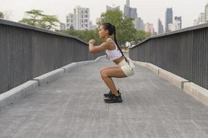 en ung fitness kvinna i sportkläder tränar i stadsparken, hälsosam och livsstil. foto