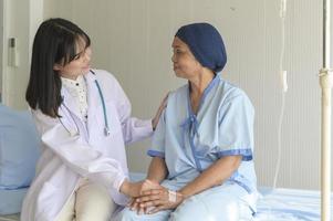 läkare håller senior cancerpatients hand på sjukhus, hälsovård och medicinskt koncept foto