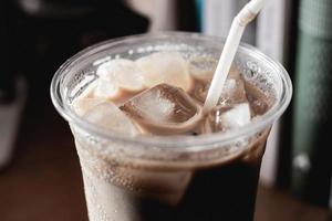 närbild iskaffe i plastglas och vit tub foto