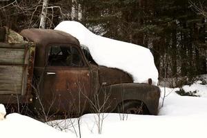 övergiven gammal lastbil täckt med snö pack foto