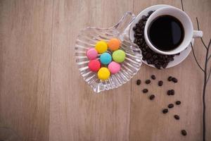 kopp espressokaffe med färgglada franska macarons foto