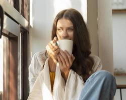 kopp te eller kaffe. kvinna som dricker varm dryck och njuter av morgonen, foto