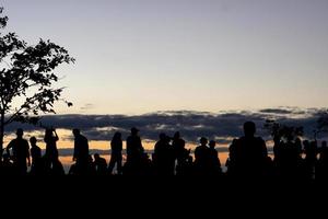 siluett av turister som väntar på att se soluppgången foto