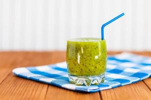 hälsosam hemlagad färsk kiwi juice i glas på träbakgrund foto