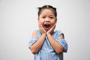 porträtt av asiatiskt barn 5 år gammal och att samla hår och ett stort leende på isolerad vit bakgrund, hon är lycka, utstrålning i ungdomen foto