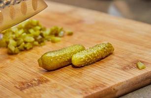 kocken skär pickles med kniv för att förbereda allt enligt receptet foto