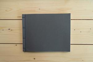 klassisk svart anteckningsbok på träbordet. foto