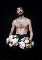 ung man med blommor på svart bakgrund foto