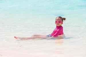 bedårande liten flicka på stranden under sommarlovet foto