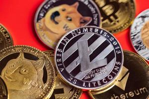 dogecoin doge-grupp inkluderad med kryptovaluta mynt bitcoin, ethereum eth, silver litecoin ltc, symbol virtuell blockchain-teknologi framtiden är pengar förlora närbild på röd bakgrund foto