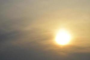 den nedgående solen i diset och molnen foto