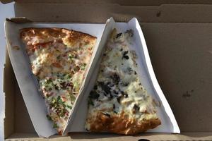 en skiva pizza i en kartong foto