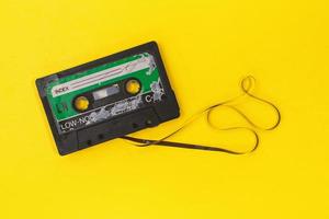gamla retro kassettband med grunge etikett omgiven av dragna tejp hög på gul bakgrund platt låg foto