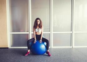 kvinna avkopplande på bollen i gymmet foto