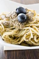 spaghetti med svart olivpesto. foto