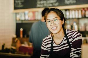asiatisk kvinna amiling arbete i småföretagare mat och dryck café. foto