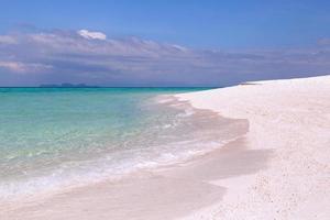 vackert hav med vit sandstrand och blå himmel i tropisk ö. foto