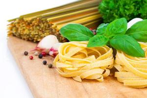 italiensk pasta fettuccine rede med vitlök och färska basilikablad
