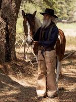 cowboy rör vid hästen med kärlek foto