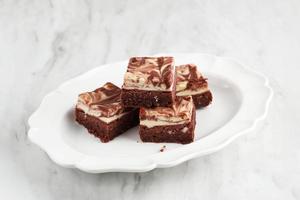 röd sammet cream cheese brownies på vit maträtt foto