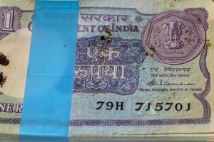 gamla en rupier sedlar kombinerade på bordet, Indien pengar på det roterande bordet. gamla indiska valutasedlar på ett roterande bord, indisk valuta på bordet foto