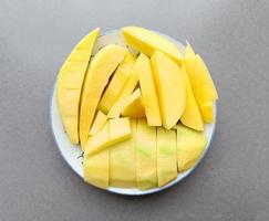 grön mango skivad på en vit tallrik thai frukt sommar, ovanifrån foto